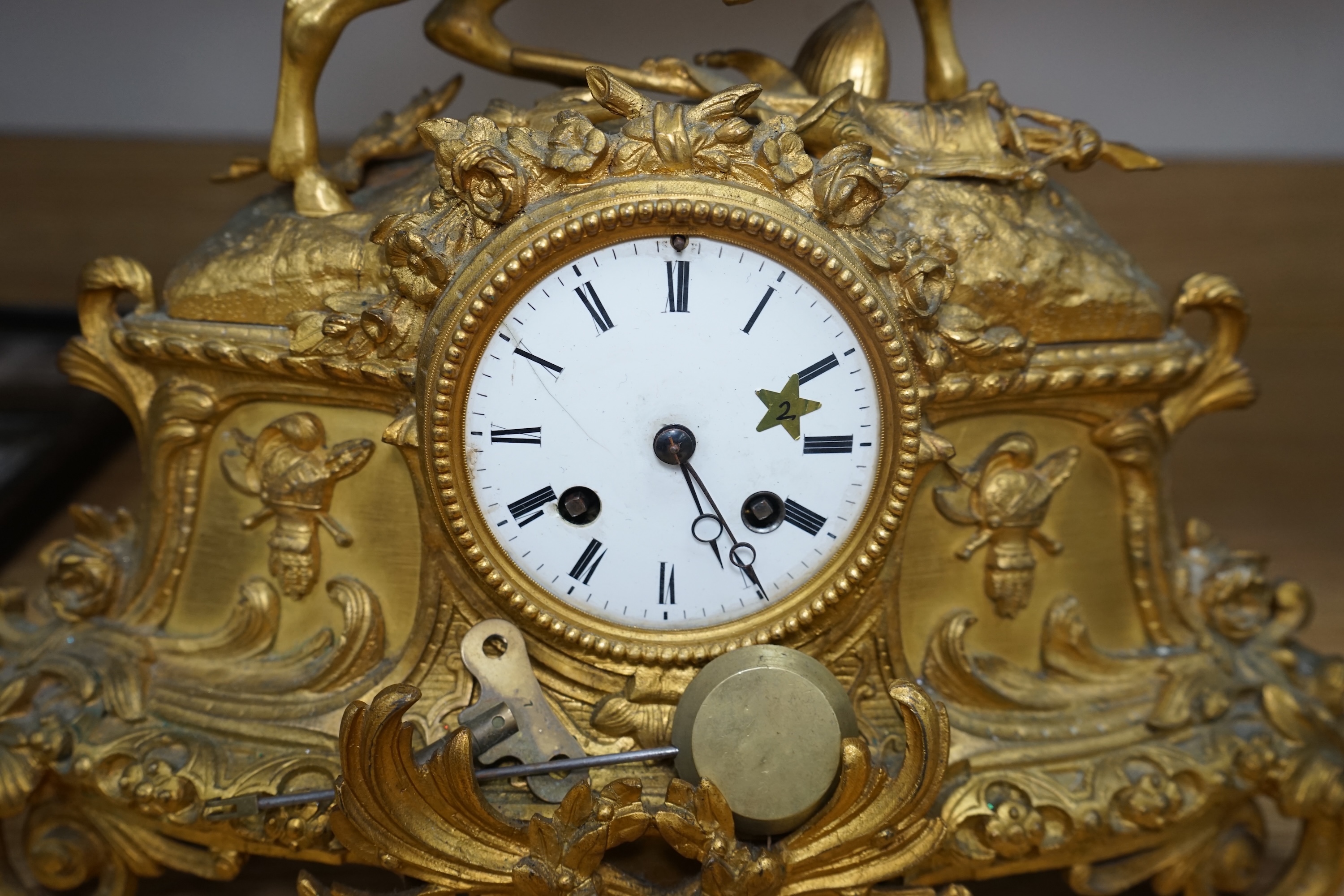 A late 19th century French ormolu mantel clock surmounted with a cavalier on horseback, key and pendulum, 38cm. Condition - fair to good